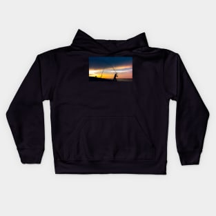 Fisherman cast fishing rods on the seashore at a dramatic sunset. Kids Hoodie